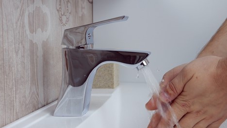 person holding stainless steel faucet